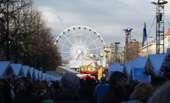 Marché de Noël illuminé avec grande roue et visiteurs
