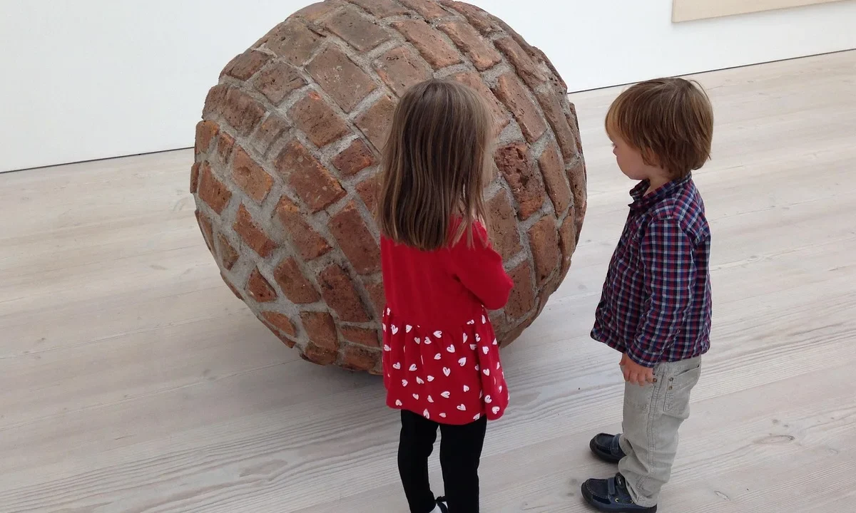 Deux enfants observent une œuvre dans un musée