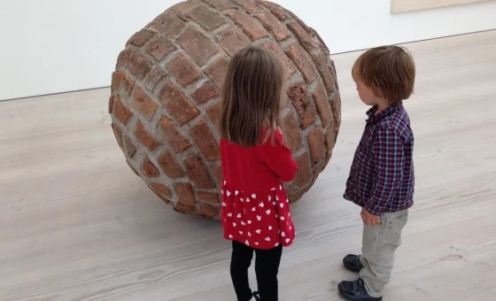 Deux enfants observent une œuvre dans un musée